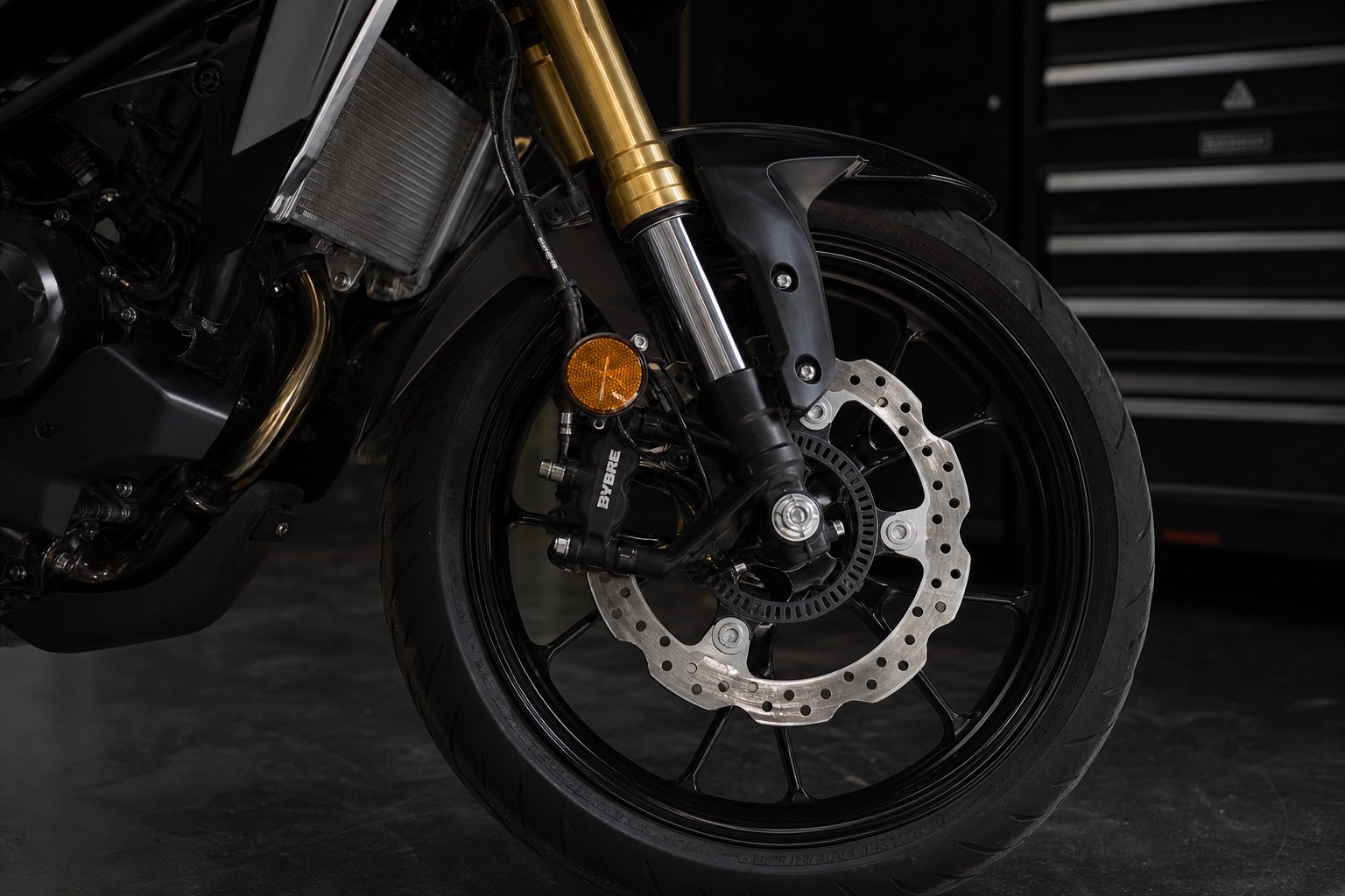 Detailaufnahme des Vorderrads einer 125er-Sportmaschine mit Upside-down-Gabel, Bremssattel und Bremsscheibe